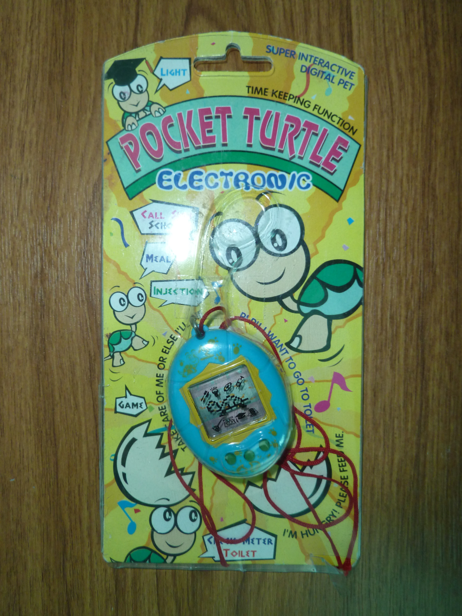 Photo of the turtle Tamagotchi, with red string